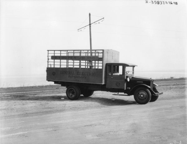 An International Harvester truck parked outdoors. The sign painted on the side of the truck reads: "R. Cooper Jr., Inc. General Electric Refrigerators."