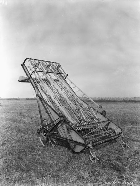 A McCormick-Deering hay loader/stacker in a field.