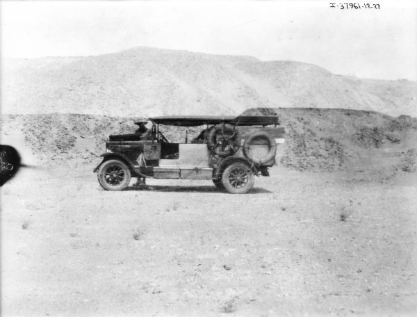 View towards a man standing behind a "Saraha" truck. Hills are in the background.