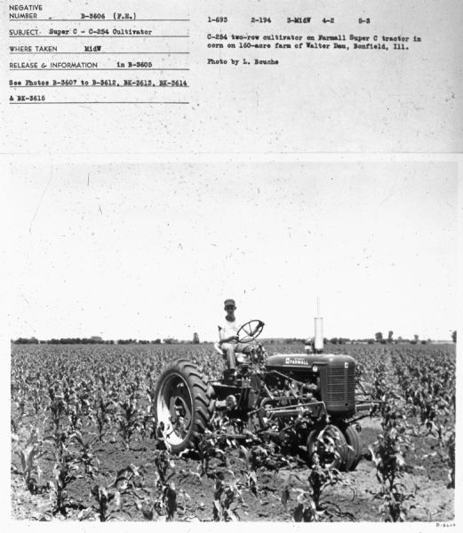 Three-quarter view from front right towards a man is driving the tractor in a field.
Subject: "Super C — C-254 Cultivator." Where Taken: "MidW." Information with photograph reads: "C-254 two-row cultivator on Farmall Super C tractor in corn on 160-acre farm of Walter Dau, Bonfield Ill. Photo by L. Bouche."