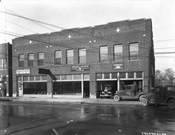 View across street towards dealership. Signs on the front of the building read: "Herrin Bro's. Cotton Co. Cotton Factors." and "Clarksdale International Co."