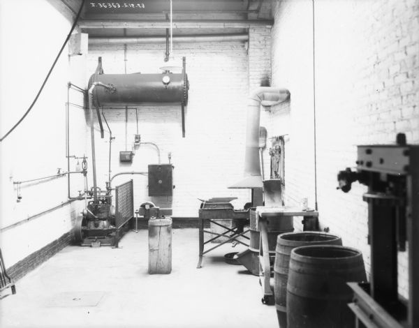View of a room with brick walls and a high ceiling. There is equipment on the far wall, and along the right wall.