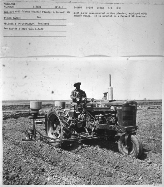 Three-quarter view from front right of a man on a Farmall MD. Subject: "M-57 Cotton Tractor Planter & Farmall MD." Where Taken: "Pac." Information with photograph reads: "M-57 4-row rear-mounted cotton planter, equipped with runner wings. It is mounted on a Farmall MD tractor."