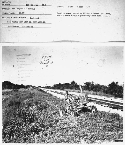 View towards a man using an International Super A tractor to mow along the side of railroad tracks. Subject: "Inter. Super A — Mowing." Where Taken: "MidW." Information with photograph reads: "Super A mower, owned by Illinois Central Railroad, mowing weeds along right-of-way near Alma, Ill."