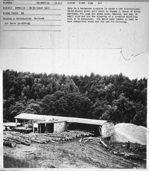 Elevated view of sawmill. Subject: "Sawmills — UD-24 Power Unit." Where Taken: "NE." Information with photograph reads: "Here in a backwoods location is shown a new International UD-24 Diesel power unit owned by Thomas J. Moran of North Hartland, Vt. Logs are mixed pine, hemlock, and oak, of small size and are the clean-up of a location which was soon to be abandoned. The white pine lumber is used to make ammunition boxes and the oak for flooring."