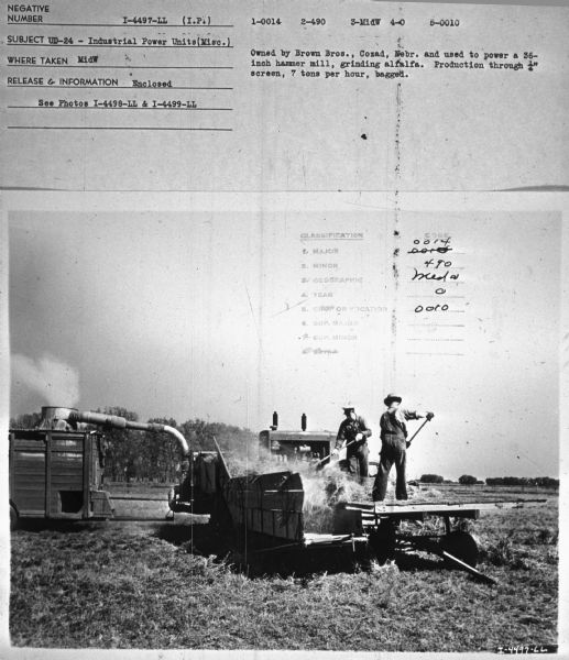 Men are standing on a trailer working with alfalfa. The UD-24 is on the back of a truck. Subject: "UD-24 — Industrial Power Units (Misc.)." Where Taken: "MidW." Information with photograph reads: "Owned by Brown Bros., Nebr. and used to power a 36-inch hammer mill, grinding alfalfa. Production through 1/4" screen, 7 tons per hour, bagged."