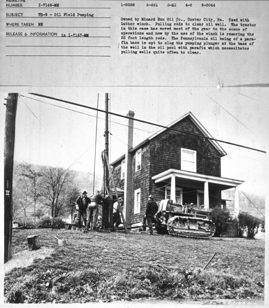 Subject: "TD-9 — Oil Field Pumping." Where Taken: "NE." Information with photograph reads: "Owned by Minard Run Oil Co., Custer City, Pa. The tractor in this case has moved most of the gear to the scene of operations and now by the use of the winch is removing the 25 foot length rods. The Pennsylvania oil being of a parafin base is apt to clog the pumping plunger at the base of the well in the oil pool with parafin which necessitates pulling wells quite often to clear." 