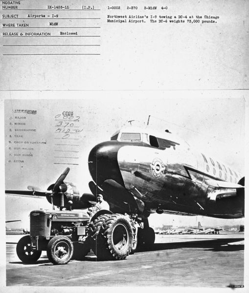 Subject: "Airports — I-9." Where Taken: "MidW." Information with photograph reads: "Northwest Airline's I-9 towing a DC-4 at the Chicago Municipal Airport. The DC-6 weights[sic] 73,000 pounds."	