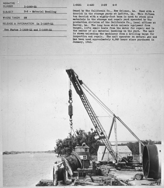 Subject: "U-9 — Material Handling." Where Taken: "SW." Information with photograph reads: "Owned by The California Co., New Orleans, La. Used with a derrick in the storage yards at Lafitte, La. This fifteen ton derrick with a eighty-foot boom is used to stock pile materials in the storage and repair yard operated by the production division of the California Co., local offices at Harvey, La. The long boom which unloas equipment from barges, lifts small boats from the water for repair and is the center of all material handling in the yard. The unit is shown unloading the machinery from a drilling barge for inspection and repair. The unit operates on natural gas and has been used approximately 4,000 hours since purchased in January, 1946."