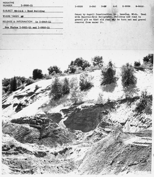 Subject: "TD-14A — Road Building." Where Taken: "MS" Information with photograph reads: "Owned by Angell Construction Co., Lansing, Mich. Used with Bucyrus-Erie bullgrader. Building new road in gravel pit so that old road may be torn out and gravel removed from under it."