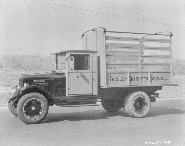 View towards the driver's side of a delivery truck. The sign on the truck bed reads: "Trolley Transfer Service."