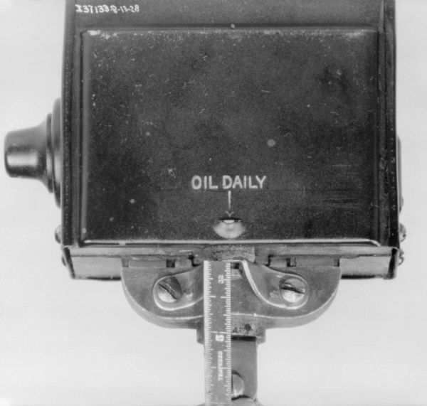 Close-up of a part on a 1 1/2 H.P. engine with an indicator for "Oil Daily."
