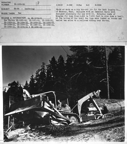 View uphill towards a man using a TD-24. Subject: "TD-24 — Lumbering." Where Taken: "Pac." Information with photograph reads: "TD-24 at work on a big try-out job for the Ladd Logging Co., of Mineral, Wash. Equipped with an Isaacson Karry arch designed especially for use with it. Bringing loads of Douglas fir logs from 6,000 to 7,000 feet in size down a trail. At the bottom of the trail the logs were loaded on trucks and hauled ten miles to a railroad siding near Morton."