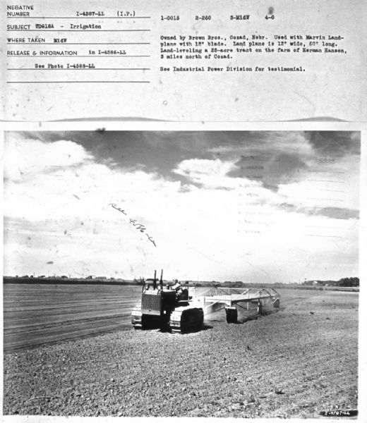 View of a man driving a TD-18A in a field. Subject: "TD-18A — Irrigation." Where Taken: "MidW." Information with photograph reads: "Owned by Brown Bos., Cozad, Nebr. Used with Marvin Land-plane with 12' blade. Land plane is 12' wide, 60' long. Land-leveling a 25-acre tract on the farm of Herman Hansen, 3 miles north of Cozad."