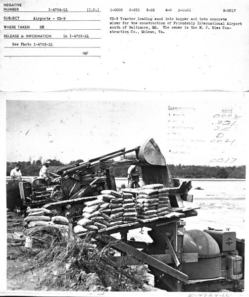 View of men working with concrete mixer. Subject: "Airports — TD-9." Where Taken: "MidW." Information with photograph reads: "TD-9 Tractor loading sand into hopper and into concrete mixer for the construction of Friendship International Airport south of Baltimore, Md. The owner is the M.J. Bles Consctruction Co., McLean, Va."	