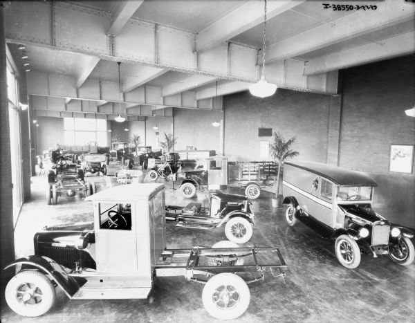 Elevated view of large showroom, with trucks on display. A number of the trucks have open chassis.