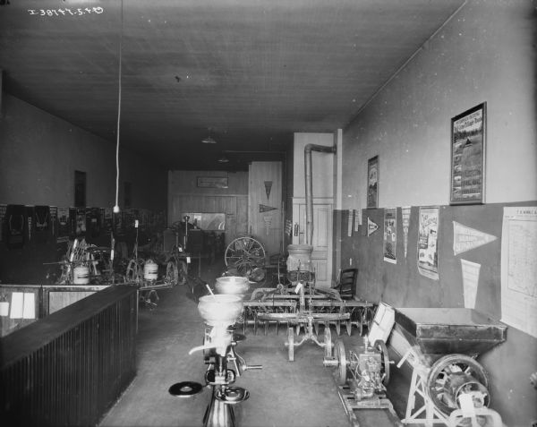 View of dealership showroom, with cream separators and agricultural equipment on display.