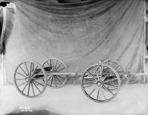 Columbus Wagon Chassis set up on a wood floor. There is a dark backdrop in the background.