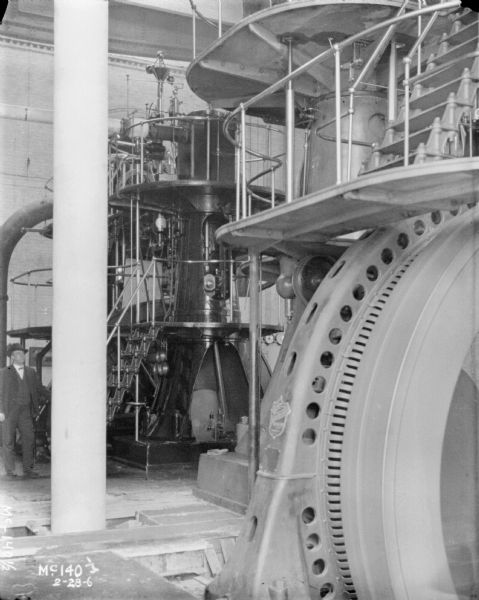 Turbines inside plant at McCormick Works. A man is standing near the turbines on the left.