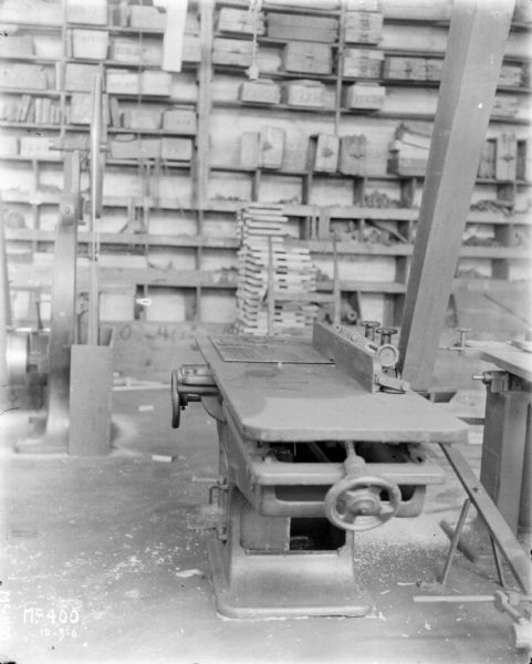 A saw in a work area at McCormick Works. Shelves are along the wall in the background.