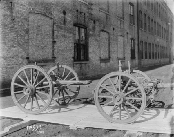 Right side view of a Weber wagon chassis set up on a wooden pallet outdoors at McCormick Works.
