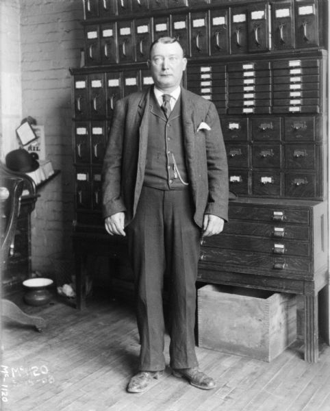 A man wearing a business suit is standing in an office at McCormick Works.
