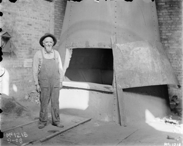 Portrait of a male employee wearing overalls, standing in foundry area.