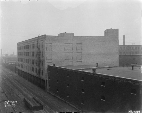 Elevated view of railroad tracks running along near the sides of factory buildings at MCcormick Works.