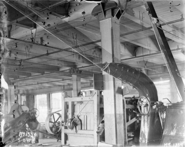 Thresher indoors in a factory building at McCormick Works.