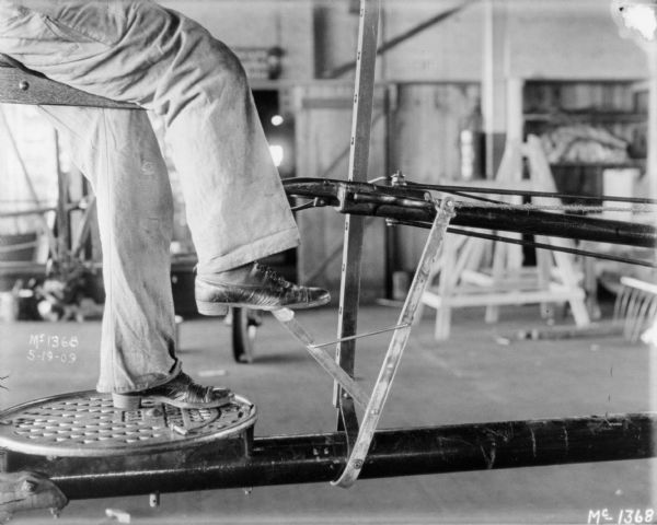Close-up of a man's feet and legs operating a push binder indoors at McCormick Works.