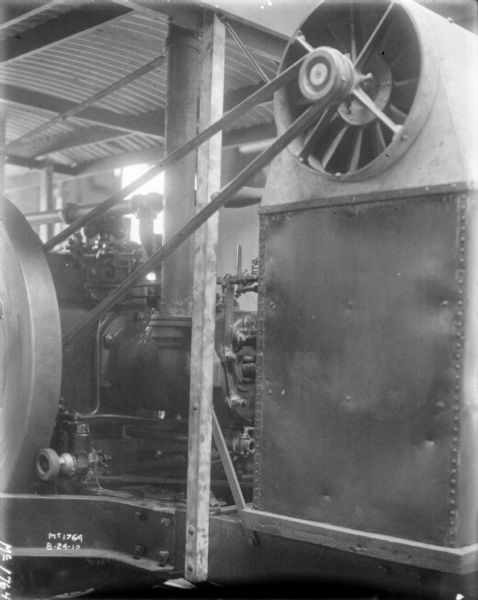 Close-up of belt-driven machine inside a factory building.