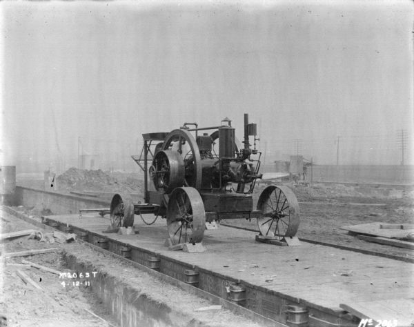 View of a new IHC Titan (?Mogul Tractor) tank-cooled portable engine loaded onto a flatcar for shipment from IHC's Milwaukee Works, Milwaukee, Wisconsin. Such engines were available in a range of models, from 4 to 25 HP.