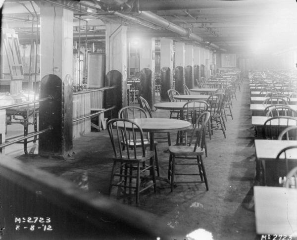 View of the employee dining room, which has rows of tables and chairs.