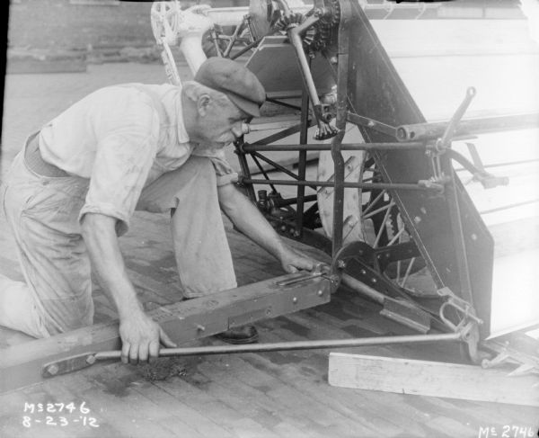 Man assembling parts on a Binder outdoors in the yard at McCormick Works.