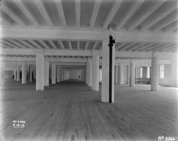 View of large, empty interior, with columns.