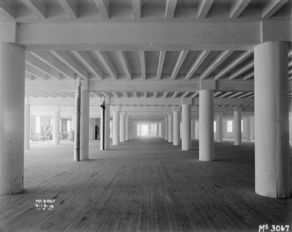 View of large, empty interior, with columns.