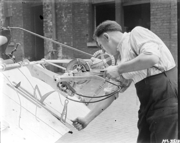 Man demonstrating loading of twine on a Binder outdoors in the factory yard.