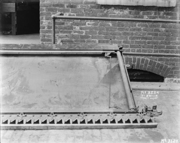 Close-up of blade and bed of a Binder in the factory yard near a brick factory building.