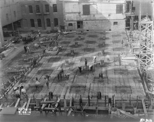 Elevated view of men arranging steel cables for building.