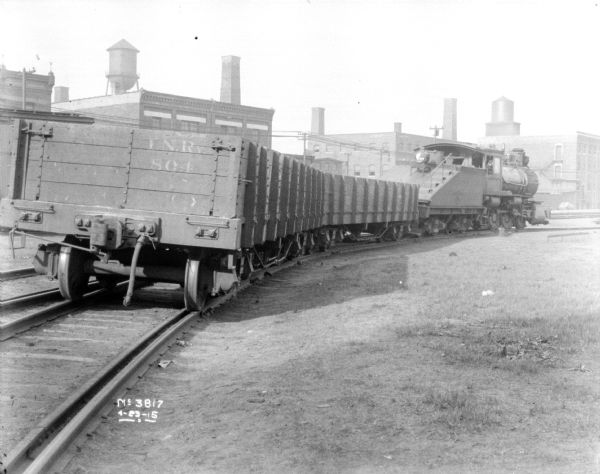 View of loaded boxcars on railroad tracks outside plant.