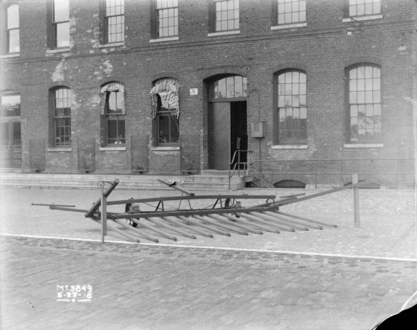 Sweep Rake outdoors in factory yard. In the background is a brick factory building.