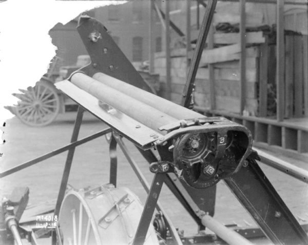 Close-up of machine displayed outdoors in the factory yard at McCormick Works. There is a brick factory building in the background.