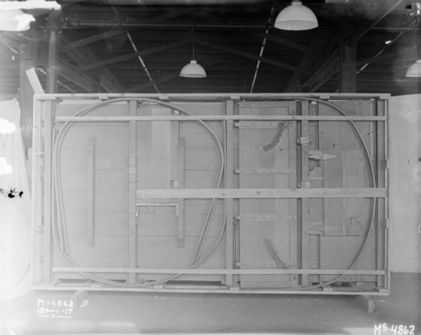 A box has been turned on it's side on a factory floor, showing the interior with metal parts. White cloth backdrops are set up around the wagon.