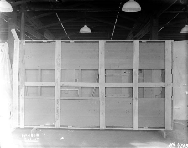 A box has been turned on it's side on a factory floor, showing the interior with metal parts. White cloth backdrops are set up around the wagon.