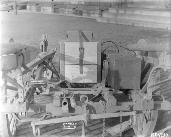 Details of loaded guns and ammunition on a Gun Cart outdoors in factory yard, with a brick building in the background.