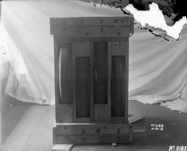 Machine crated for shipment. There is a white cloth backdrop in the background.