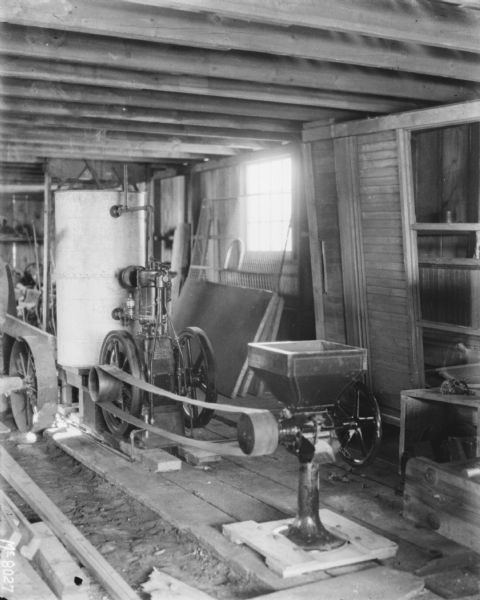 Belt-powered feed mill in a building.