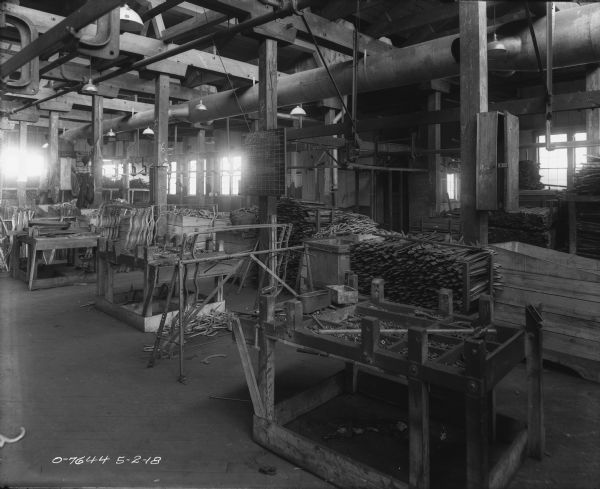 Interior view of a manufacturing area, with parts stacked on tables and in bins.