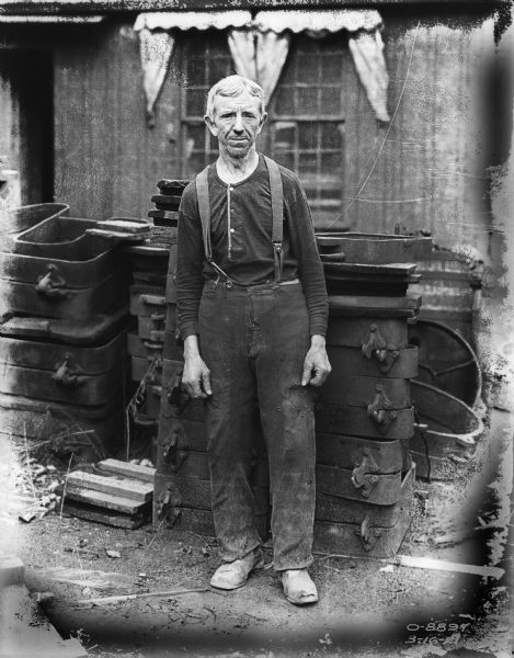 Full-length portrait of a man posing in foundry area.