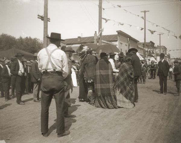 Groups of Ho-Chunk and non-Indians gathering on the streets of Black River Falls during the 1908 Homecoming Celebration.